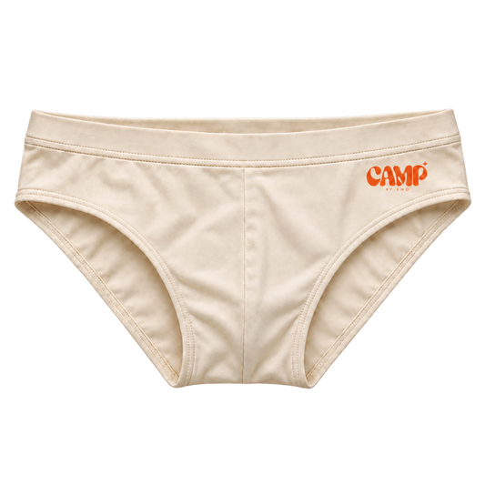 Front view of the CAMP Poolside Brief in Cabana Cream, with a warm cream finish and orange CAMP logo.