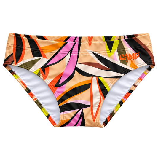 Front view of the CAMP Sun Bather Swim Brief in Tropic Like Its Hot, with a tan ground, colourful tropical leaf print, and orange CAMP logo.